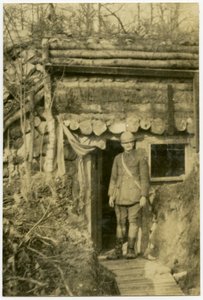 Soldier Standing in Doorway of Shelter Built Into the Side of a Small Hill